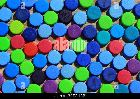 Different colored plastic water bottle caps. Colored plastic recycling materials. Stock Photo