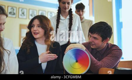 Students in physics class spin Newton's multicolored disk. Stock Photo