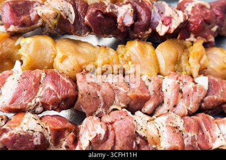 Three types of meat skewered on skewers, close-up. Stock Photo