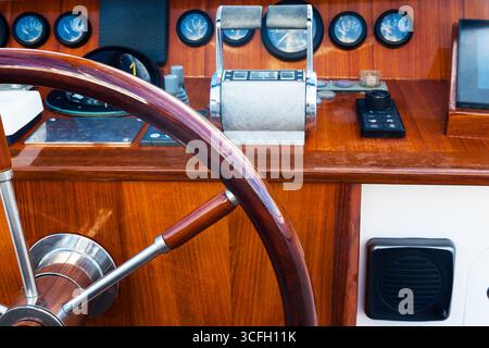 Motor yacht control panel. Steering wheel, gear levers, gauges, speedometers and control buttons. Stock Photo