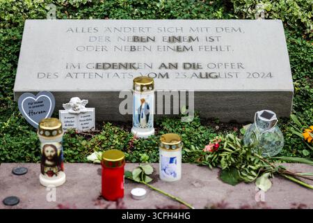 Solingen, Germany. 23rd Aug, 2025. A memorial stone commemorates the victims of the terrorist attack in Solingen on August 23, 2024, candles and flowers are laid in front of it. Credit: Christoph Reichwein/dpa/Alamy Live News Stock Photo