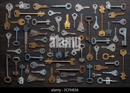 Set of different old keys on wooden background, top view, close up. Safety and security concept. Pattern of many keys Stock Photo