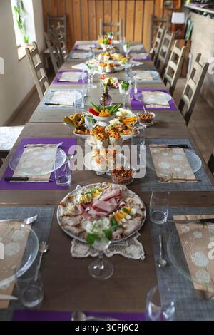 A long table with a table setting in a rustic room, decorated with flowers and crockery, Lower Austria Austria Stock Photo