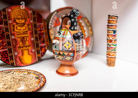 Traditional Andean ceramic pottery set displayed on shelf with colorful hand painted patterns and Peruvian cultural art Stock Photo