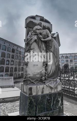 Stone funerary sculpture of a mourning woman leaning on a tomb in Presbitero Maestro Cemetery, Lima, Peru, under cloudy sky grey Stock Photo