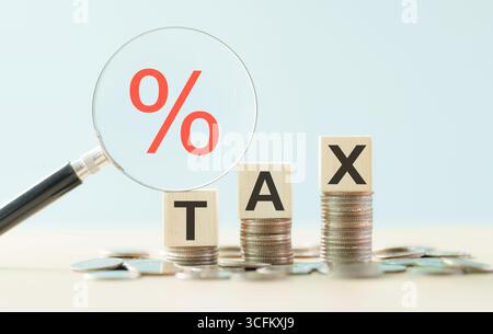 Tax payment concept. Coins money stacked with TAX text and percentage symbol inside magnifying glass. Calculation of tax return. E-tax, government, st Stock Photo