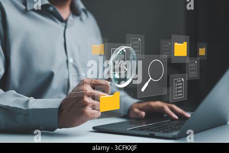 Businessman using computer to manage document files in folders. folder file storage on cloud. share database online, software for archiving and compan Stock Photo