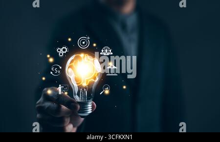 Idea solution business strategy concept. Businessman hand holding light bulb with business icons. Digital marketing, Financial and banking, Internet Stock Photo