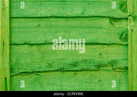 Green stained rustic wooden fence panel background backdrop. Garden boundary structure concept. Stock Photo