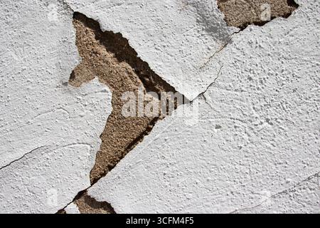 Peeling white paint on a weathered concrete wall forms an arrow pointing right. Space for copy. Stock Photo