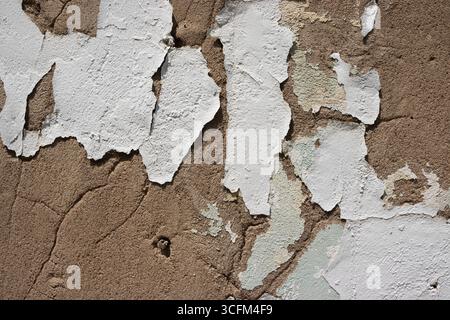 Texture of peeling white paint in a line of patches on a weathered old cracked concrete wall. Taken in Centralia, Missouri, USA. Stock Photo