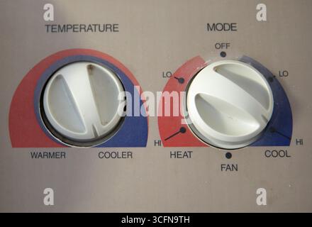 A white thermostat with a red and blue knob Stock Photo