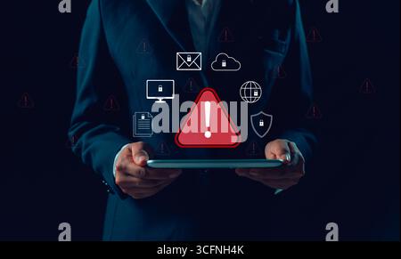 Businesswoman receives cyber security warning alert on smartphone and computer, data vulnerability, compromised information illegal, concept of digita Stock Photo