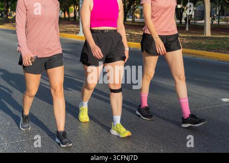 Unrecognizable group of women walking outdoors in athletic wear on a sunny day Stock Photo