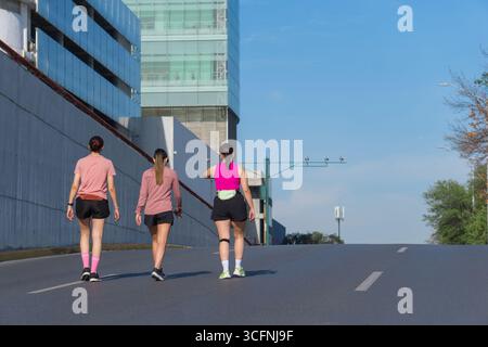 Three women walking on a city road after exercising Stock Photo