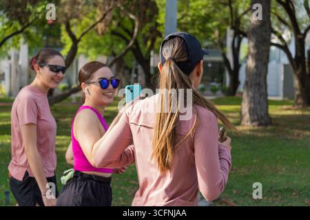 Three young Latina women smiling and taking a selfie together in park Stock Photo