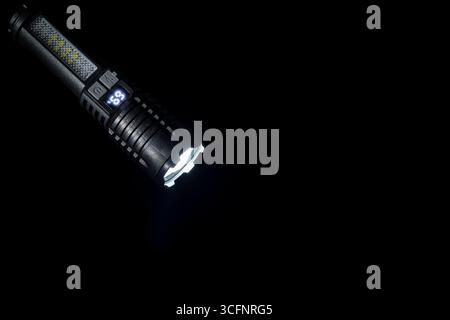 High strong power led flashlight on a black background, close up. Tactical emergency spotlight with telescopic zoom, built-in battery, usb rechargeabl Stock Photo