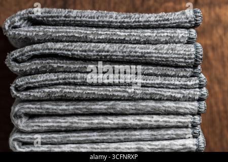 Stack of grey hand towels on wooden background, close up Stock Photo