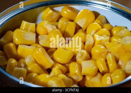 Canned pickled corn, close up. The open can with sweet corn Stock Photo