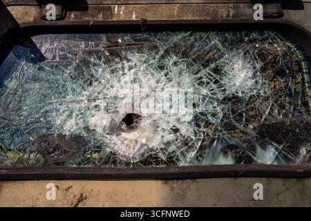 Bullet hole in armor-piercing glass. Armor piercing glass of damaged military infantry fighting vehicle during war between russia and Ukraine. Backgro Stock Photo