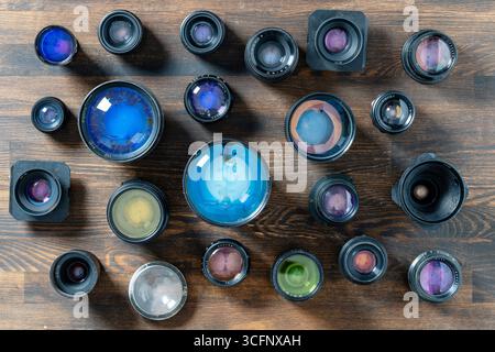 A lot of vintage camera lenses from the times of the USSR on a wooden background, close up, top view Stock Photo