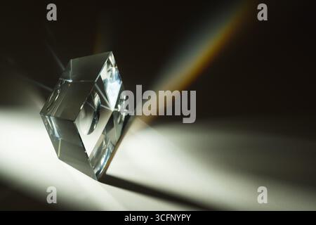 A photo capturing the stunning light refractions created by a glass prism on a white background, showcasing a spectrum of colors and optical beauty Stock Photo