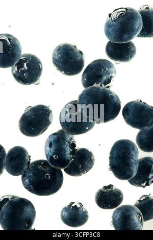 Still life of falling blueberries with small air bubbles isolated on white. Stock Photo