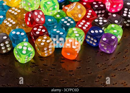 A close-up shows a group of differently coloured dice in a random arrangement. Stock Photo