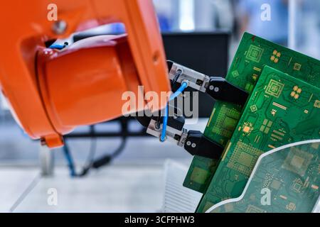 Modern Robot Arm automation system moving circuit boards in a factory ,industrial robot concept Stock Photo