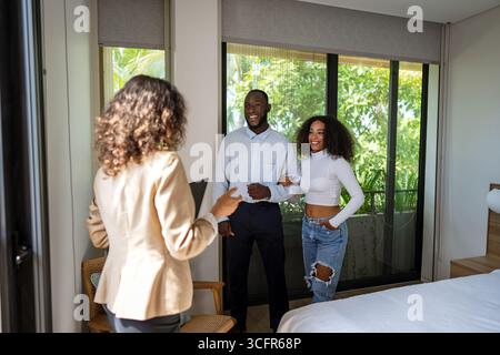 Real estate agent showing a diverse couple their new modern apartment, beautiful home tour Stock Photo