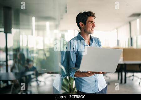 Portrait of a handsome successful young business people, software engineer with laptop in the office Stock Photo