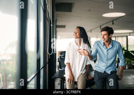 Two happy diverse multiethnic business team people working, talking in corporate office Stock Photo