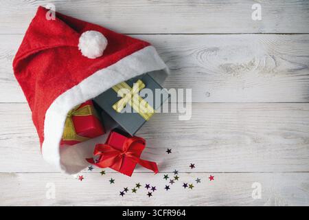 Gift boxes in a santa hat on a wooden background Stock Photo