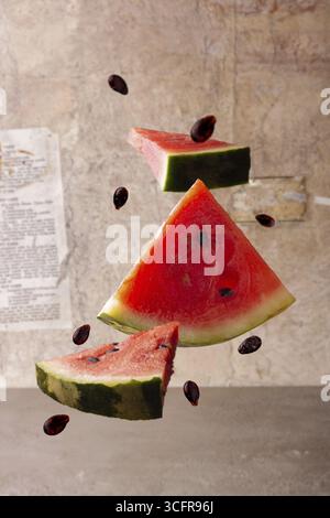 Flying pieces of watermelon on old paper background Stock Photo