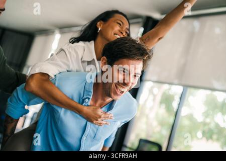 Cheerful diverse coworkers having fun during work break using technology enjoying working together Stock Photo