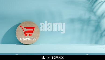 Minimalist wooden plaque with red shopping cart icon and E commerce text on light blue background with leaf shadows, concept of online business, digit Stock Photo
