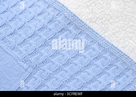 Close-up textured blue knitted fabric with white lambswool on the back, top view. Baby winter blanket for newborns Stock Photo