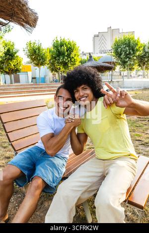 Two friends smiling and having fun in a city park Stock Photo