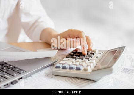 female hands doing accounting calculations using a calculator. utility services. papers invoices cheque bills, female hands holding receipt calculatin Stock Photo
