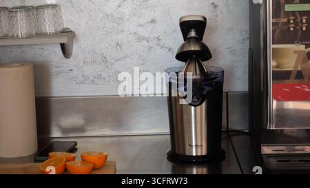 Cremona, Italy July 19th 2025 Professional citrus juicer and fresh oranges are sitting on a stainless steel counter in a bar in Lombardy, ready to pre Stock Photo