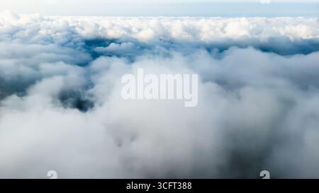 Billowy clouds fill the sky from an elevated perspective. Stock Photo