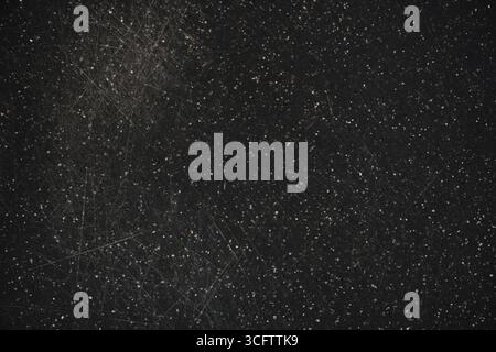Worn plastic cutting board surface background. Old dark plastic cutting board with knife marks, highlighting potential microplastic contamination. Top Stock Photo
