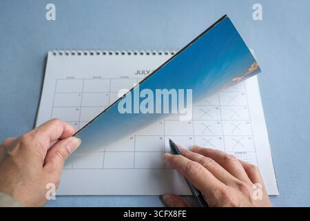 Woman's hand flipping through calendar. Meeting or event planning concept. Stock Photo