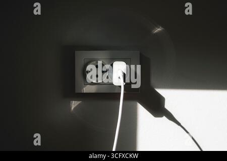 Socket on the wall with shadow. Stock Photo