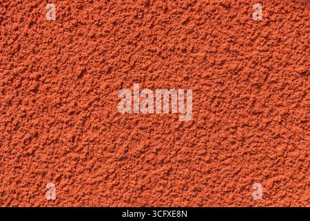 Plastered red wall with rough texture, uneven surface highlight rustic Nordic craftsmanship and natural, tactile quality. Stock Photo
