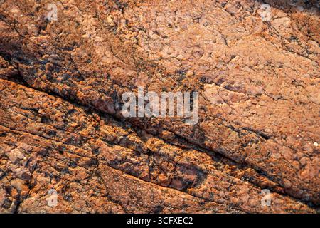 Close-up of Finnish granite. Natural stone texture with visible grains and patterns, highlighting durability, ruggedness, and northern geological feat Stock Photo