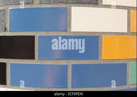 Ceramic tiles mosaic on a wall. Closeup photo of decorative, vintage, artistic tiles creating a geometric pattern. Stock Photo