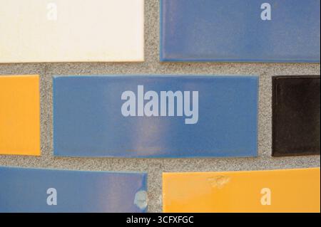 Ceramic tiles mosaic on a wall. Closeup photo of decorative, vintage, artistic tiles creating a geometric pattern. Stock Photo