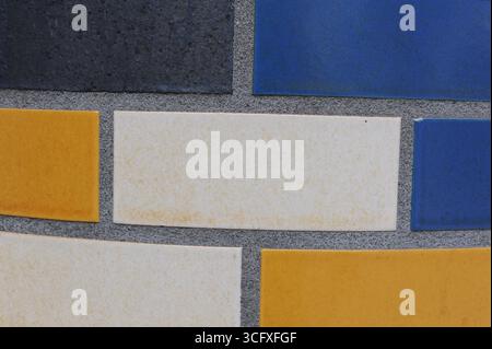 Ceramic tiles mosaic on a wall. Closeup photo of decorative, vintage, artistic tiles creating a geometric pattern. Stock Photo