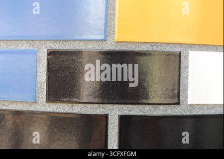 Ceramic tiles mosaic on a wall. Closeup photo of decorative, vintage, artistic tiles creating a geometric pattern. Stock Photo